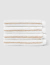 Four Cozy Earth Striped Luxe Washcloths, featuring white fabric with light beige stripes, are stacked neatly against a plain light gray background. |Color:Sand Stripe