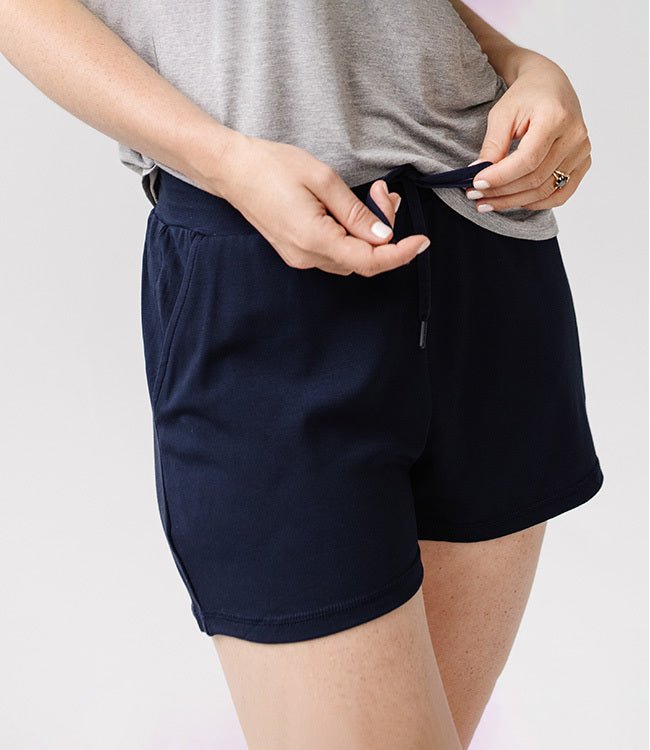 Person wearing Cozy Earth Brushed Bamboo Jogger Shorts in navy and a gray top on a light background |Color:Navy
