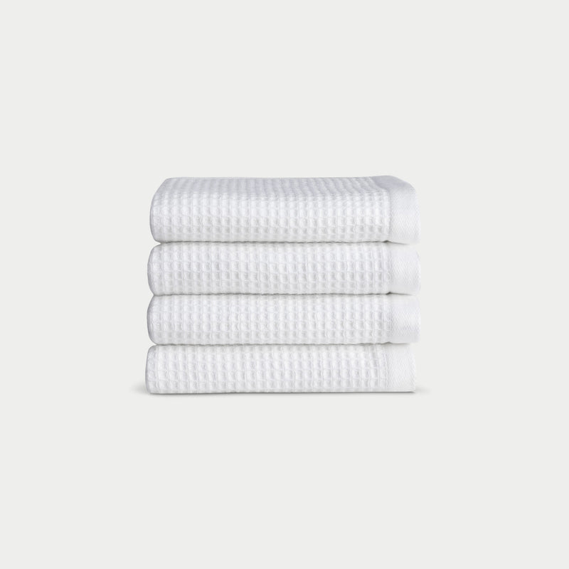 White Waffle Wash Cloths neatly folded. The photo was taken with a white background.