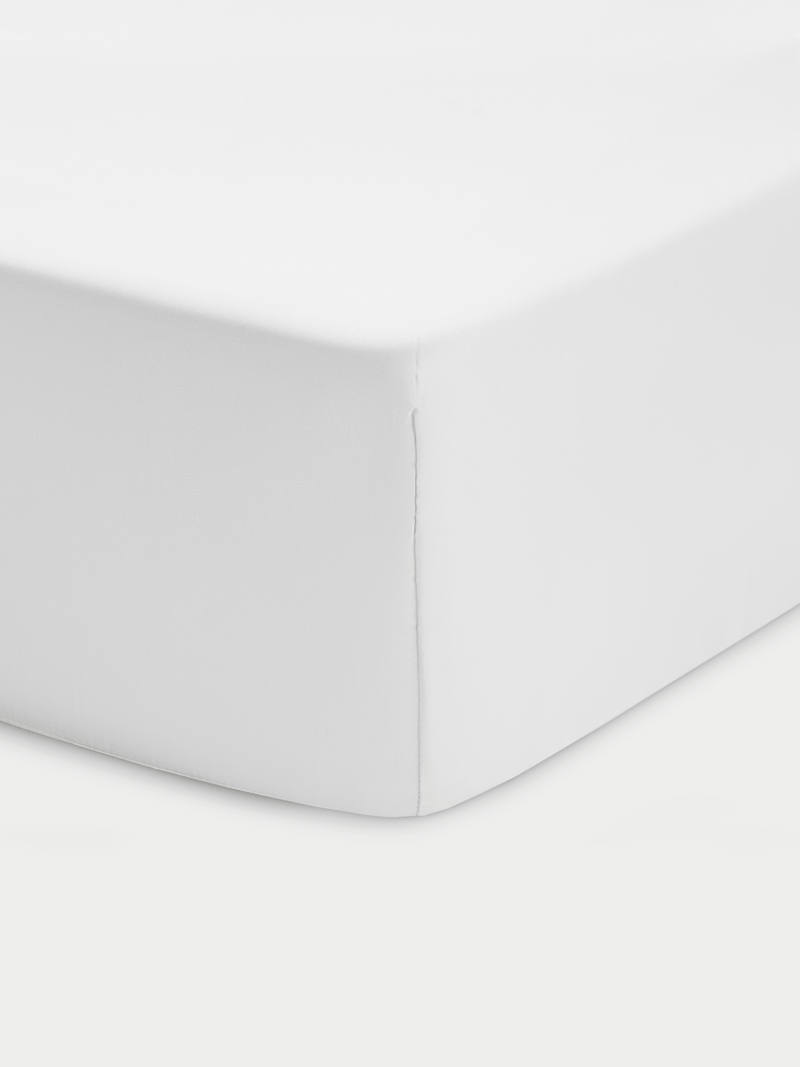 Corner of white crib sheet with white background
